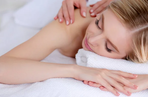 Jovem deitada em uma mesa de massagem, relaxando com os olhos fechados. Mulher. Salão de Spa — Fotografia de Stock