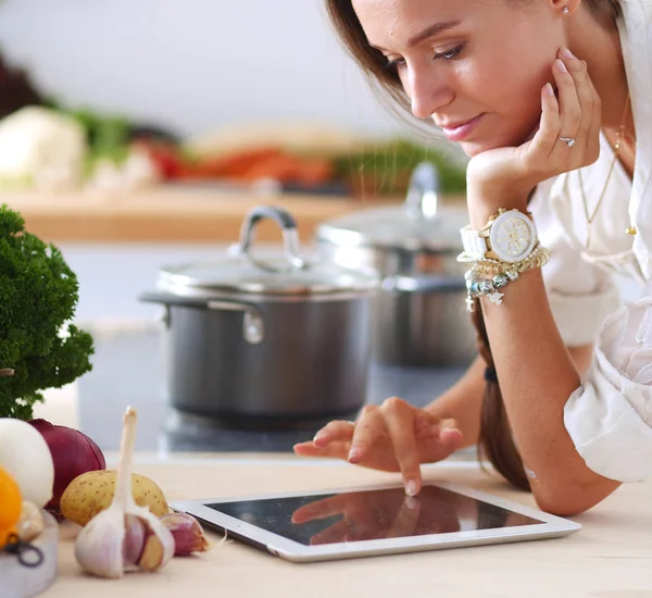 Uma jovem na cozinha, a usar o ipad. Jovem mulher — Fotografia de Stock