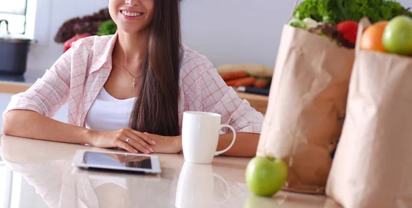 Junge Frau in der Küche, mit ihrem Ipad. Junge Frau — Stockfoto