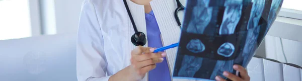 Junge lächelnde Ärztin mit Stethoskop beim Röntgen in der Arztpraxis — Stockfoto