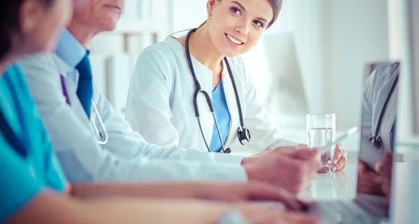 Parlak bir hastane odasında meslektaşlarıyla çalışan gülümseyen bir doktor. — Stok fotoğraf