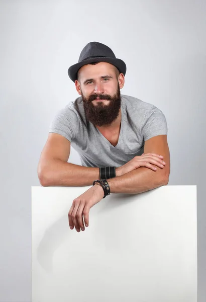 Retrato de un joven con sombrero de pie cerca del blanco — Foto de Stock