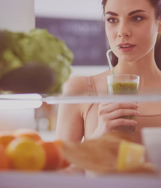 Young woman with glass of tasty healthy smoothie at table in kitchen — Stock Photo, Image