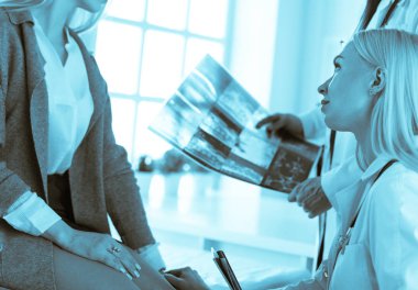 Doktor ve hasta tarama sonuçlarını tarama merkezinde tartışıyor