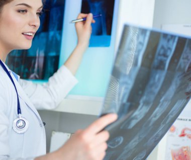 Genç, profesyonel kadın doktor hastaların röntgenlerini çekiyor.