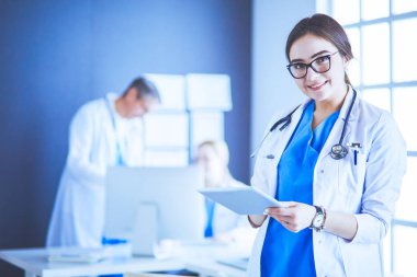 Hastane lobisinde tablet bilgisayar kullanan kadın doktor.