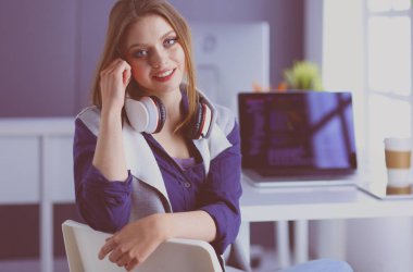 Ofisteki masanın önünde duran genç iş kadını.