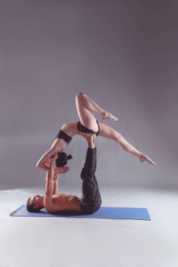 Genç çift Acro yoga mat Studio birlikte uygulamak. Acroyoga. Çift yoga. Ortak yoga