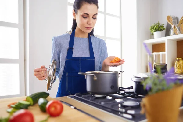 Cozinhar mulher na cozinha com colher de madeira — Fotografia de Stock