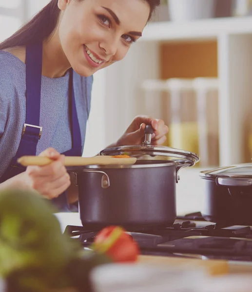 Mujer cocinera en cocina con cuchara de madera —  Fotos de Stock