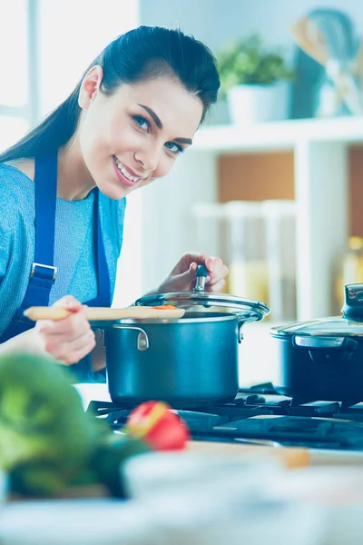 Cozinhar mulher na cozinha com colher de madeira — Fotografia de Stock