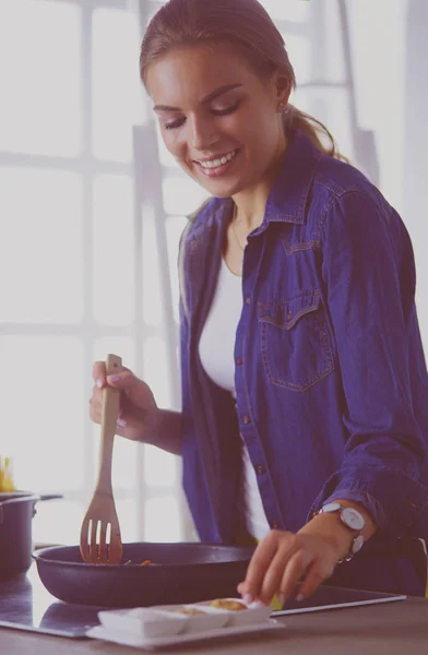 Mujer joven en la cocina preparando una comida —  Fotos de Stock