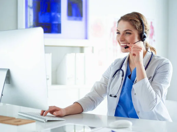 Mladý lékař doktor pracuje na recepci kliniky, je plánování schůzek a vyřizování telefonních hovorů — Stock fotografie