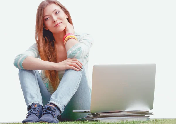 Молодая женщина с ноутбуком сидит на зеленой траве. Портрет молодой женщины — стоковое фото