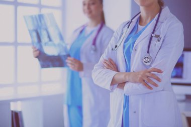 Doktorların yakın plan çekimleri ve arka planda röntgen olan meslektaşlar..