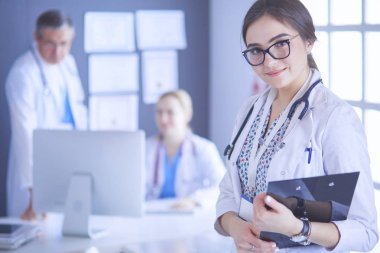 Kadın doktor hastanede steteskopla dikiliyor.