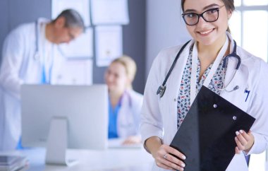 Kadın doktor hastanede steteskopla dikiliyor.