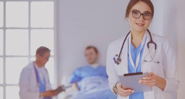 Hastane lobisinde tablet bilgisayar kullanan kadın doktor.