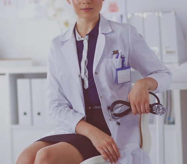 Retrato de uma jovem médica sentada à mesa no hospital — Fotografia de Stock