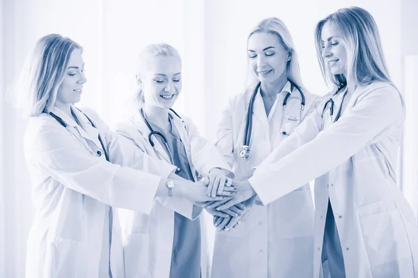 Médicos y enfermeras en un equipo médico apilándose las manos. —  Fotos de Stock