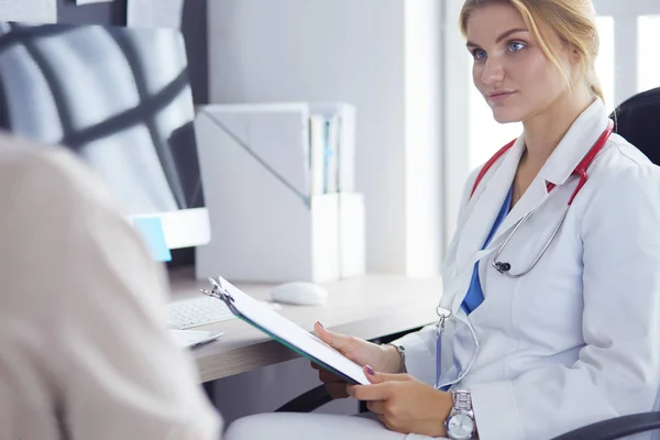 Un médecin parle et examine un patient — Photo