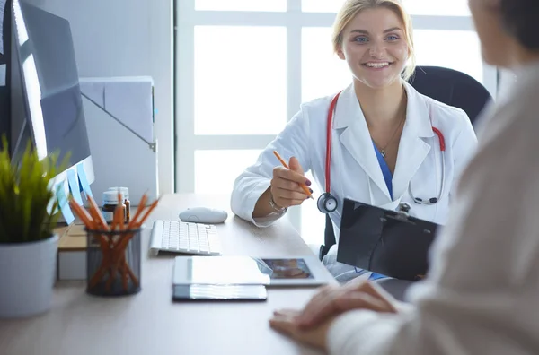 Female doctor holding application form while consulting patient