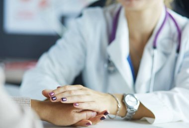 Kadın doktor yaşlılara hastanede el ele tutuşmalarında yardım ediyor