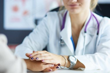 Kadın doktor yaşlılara hastanede el ele tutuşmalarında yardım ediyor