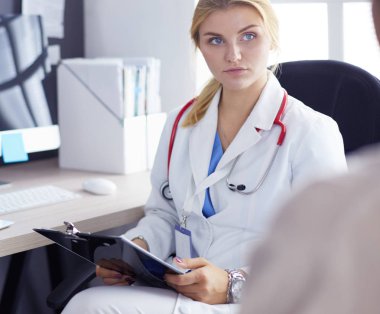 Kadın doktor, kadın hastasına teşhisi açıklıyor.