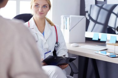 Kadın doktor, kadın hastasına teşhisi açıklıyor.