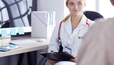 Kadın doktor, kadın hastasına teşhisi açıklıyor.