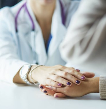 Kadın doktor yaşlılara hastanede el ele tutuşmalarında yardım ediyor