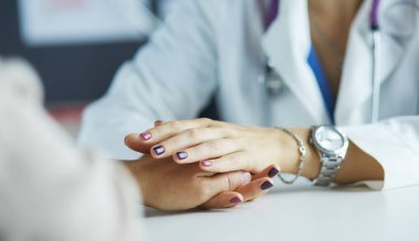 Kadın doktor yaşlılara hastanede el ele tutuşmalarında yardım ediyor