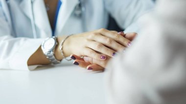 Kadın doktor yaşlılara hastanede el ele tutuşmalarında yardım ediyor