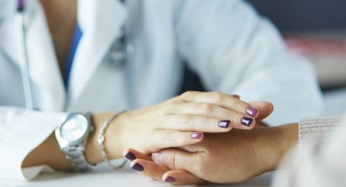 Kadın doktor yaşlılara hastanede el ele tutuşmalarında yardım ediyor