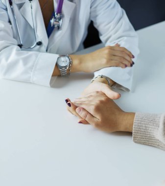 Kadın doktor yaşlılara hastanede el ele tutuşmalarında yardım ediyor
