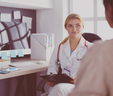 Kadın doktor, kadın hastasına teşhisi açıklıyor.