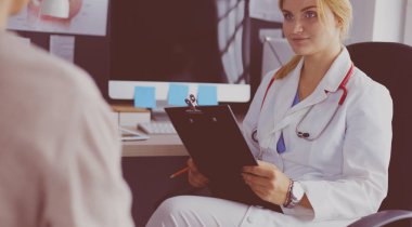 Kadın doktor, kadın hastasına teşhisi açıklıyor.