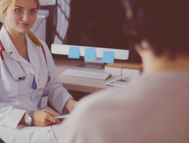 Kadın doktor, kadın hastasına teşhisi açıklıyor.