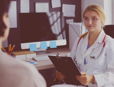 Kadın doktor, kadın hastasına teşhisi açıklıyor.