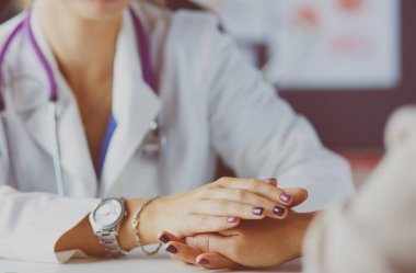 Kadın doktor yaşlılara hastanede el ele tutuşmalarında yardım ediyor