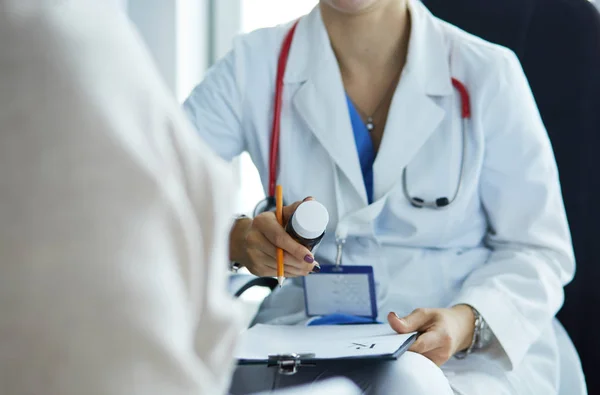 Retrato del médico explicando el frasco de medicina a su paciente —  Fotos de Stock