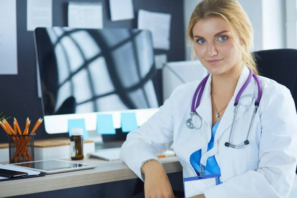 Hastanede masasında oturan genç bir kadın doktorun portresi. — Stok fotoğraf