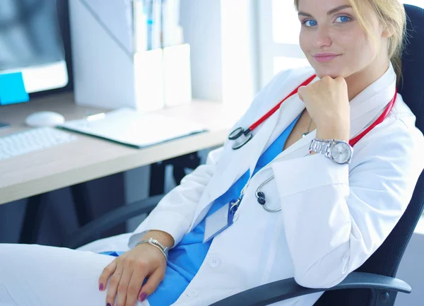 Портрет молодої жінки-лікарки, що сидить за столом у лікарні — стокове фото