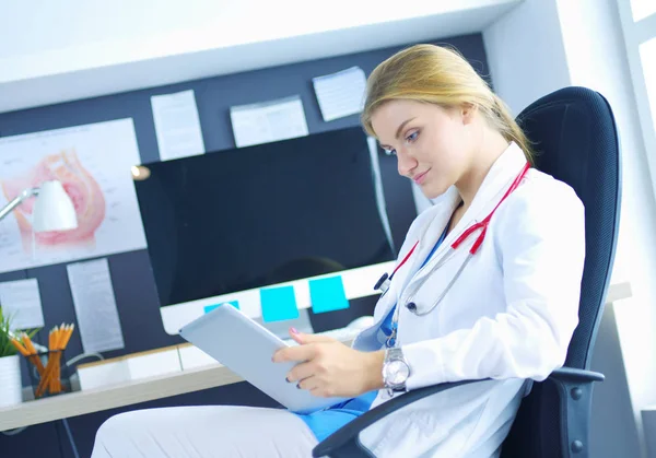 Ärztin sitzt mit digitalem Tablet am Schreibtisch — Stockfoto