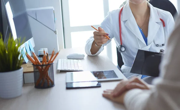 Médico femenino sosteniendo formulario de solicitud mientras consulta al paciente —  Fotos de Stock