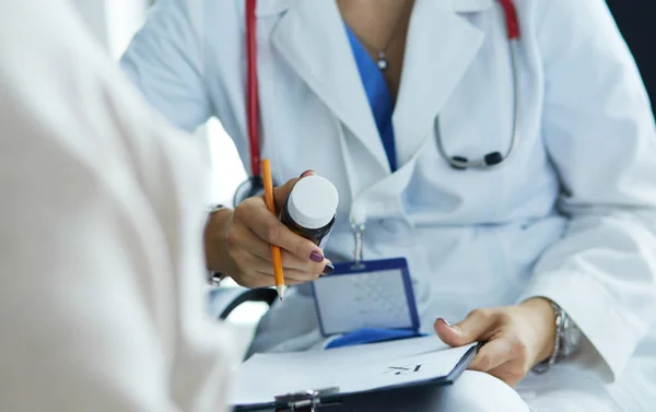 Ritratto di medico che spiega la bottiglia di medicina al suo paziente — Foto Stock