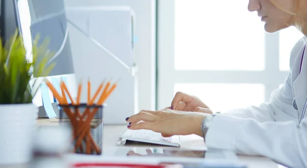 Retrato de una doctora usando su computadora portátil en la clínica —  Fotos de Stock