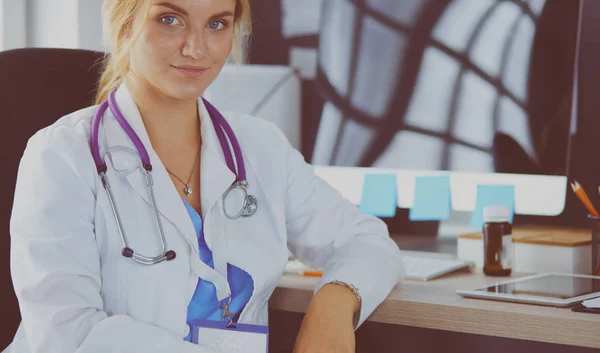 Portret van een jonge vrouwelijke arts aan het bureau in het ziekenhuis — Stockfoto