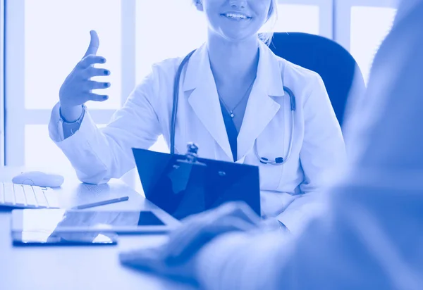 Un médecin parle et examine un patient — Photo